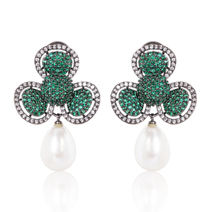 Pair of earrings with green gemstones and pearl drops on a white background