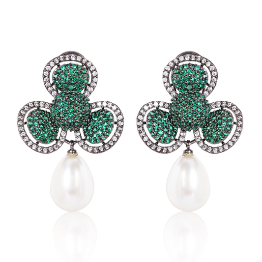 Pair of earrings with green gemstones and pearl drops on a white background