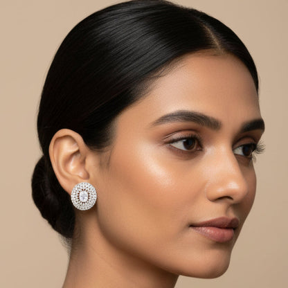 Pair of silver earrings with clear gemstones on a white background