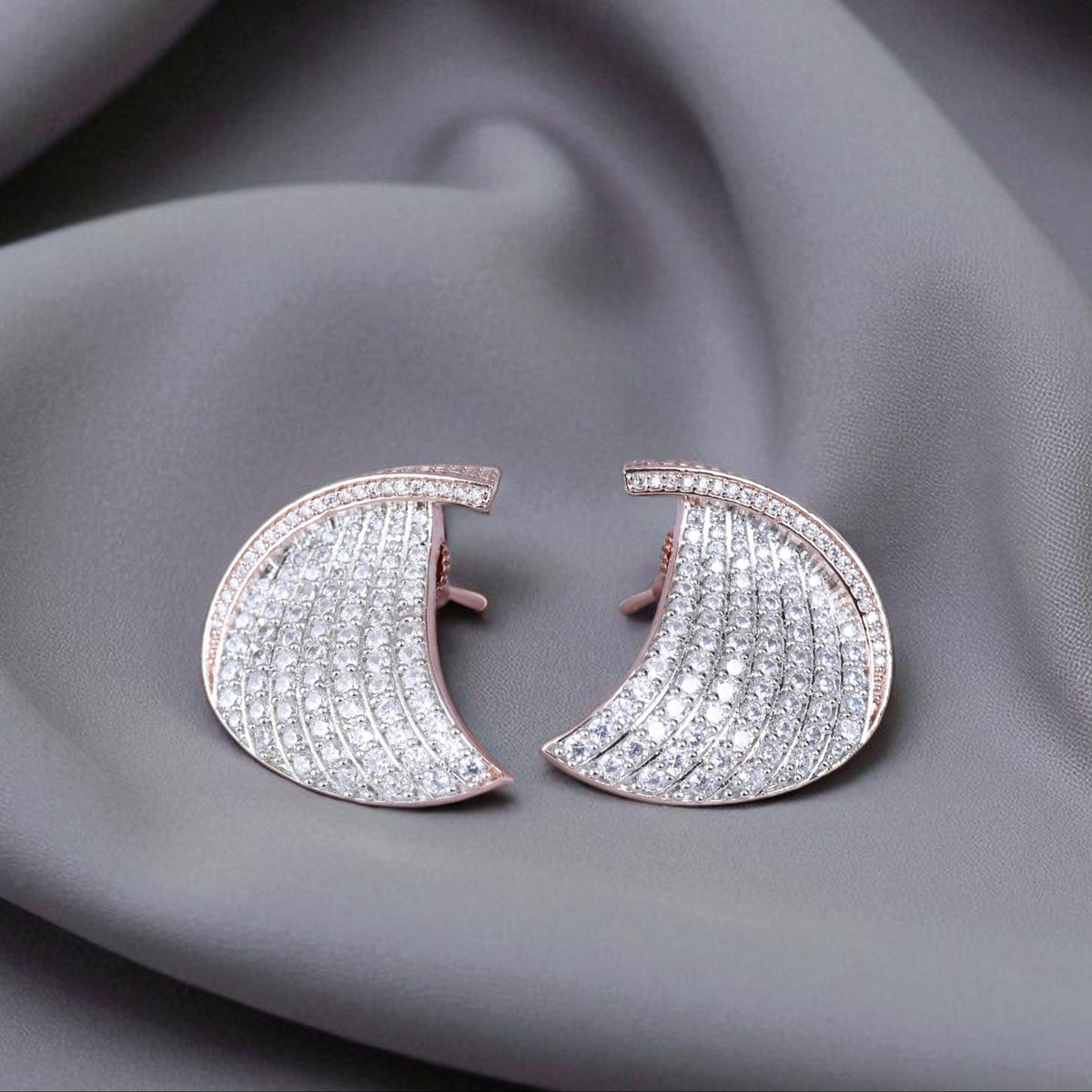 Pair of diamond earrings on a gray fabric background