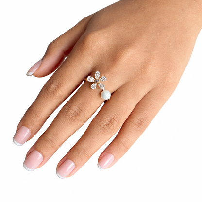 Hand wearing a decorative ring with pearls on a white background
