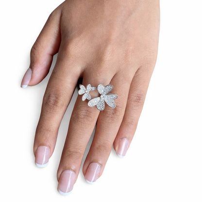 Hand wearing a silver butterfly ring on a white background