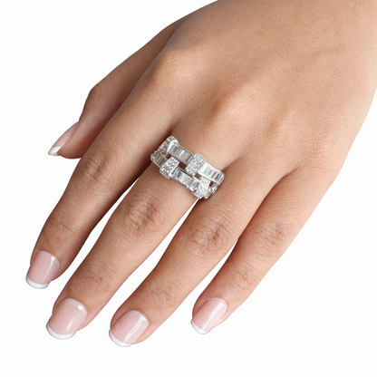 Silver ring with diamonds on a hand against a white background
