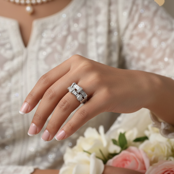 Silver ring with diamonds on a hand against a white background