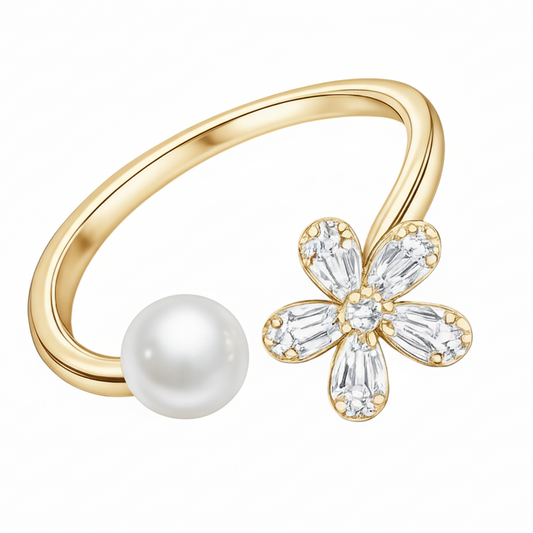Gold ring with a pearl and flower-shaped gemstone on a black background