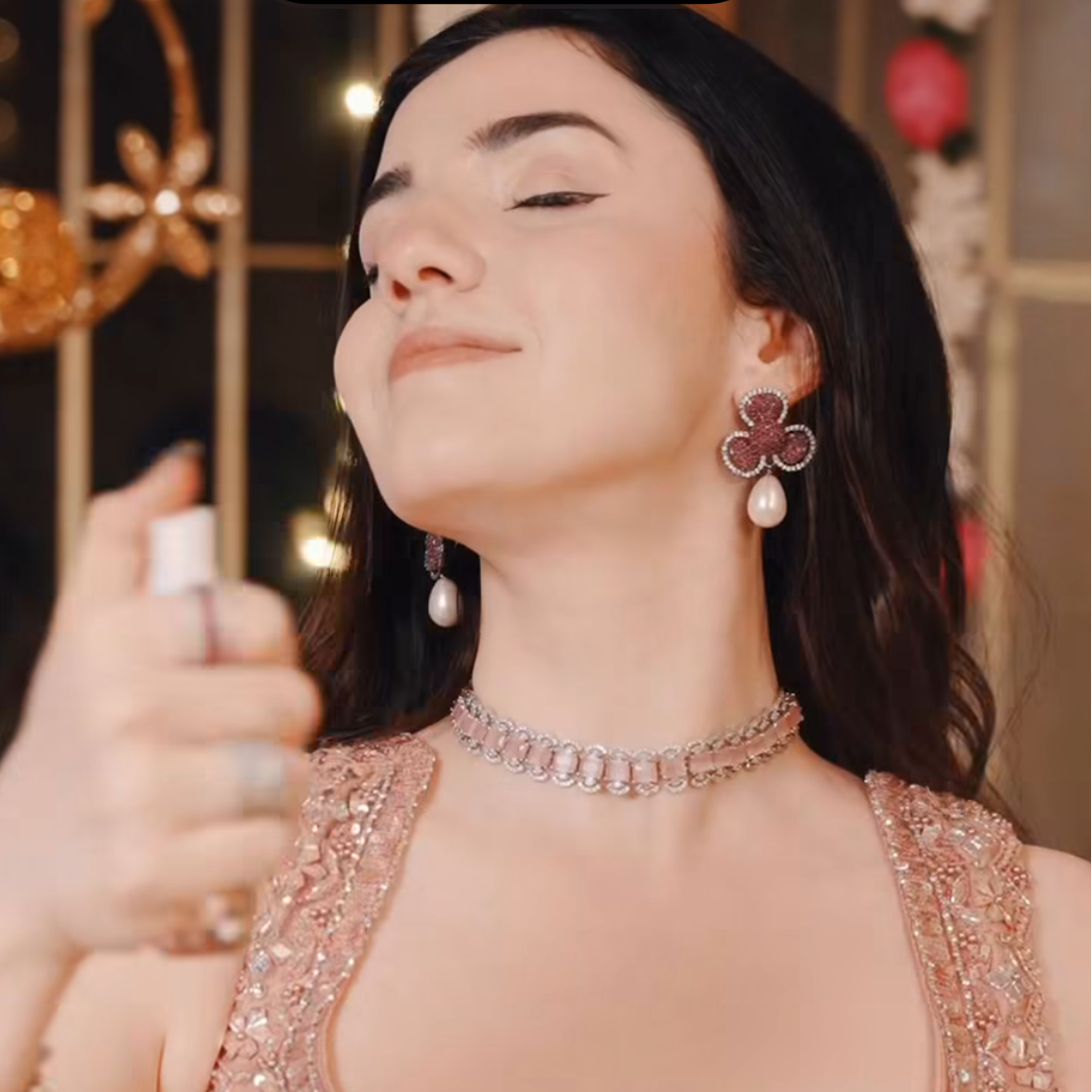 Woman holding a spray bottle labeled 'Cheirosa 68 Perfume Mist' with a blurred background