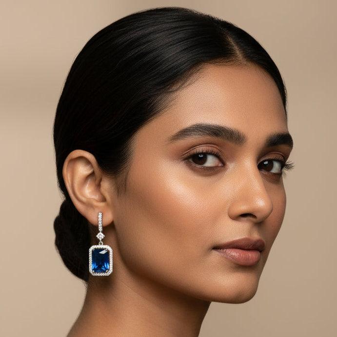 Pair of blue gemstone and diamond earrings on marble background