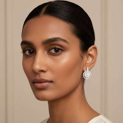 Woman wearing a silver earring against a neutral background